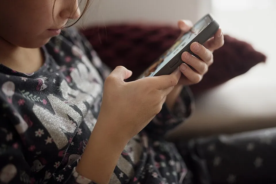 ソファでスマホのゲームをする子どもの手元